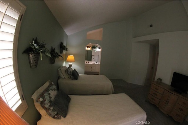 bedroom with ensuite bathroom and vaulted ceiling