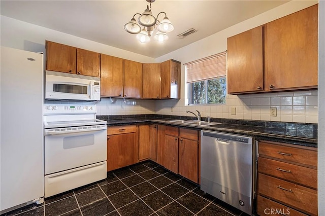 kitchen featuring backsplash, sink, and white appliances