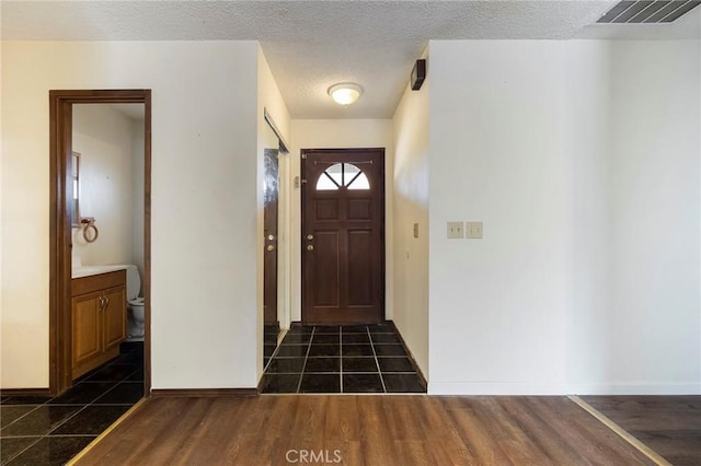 entryway featuring dark hardwood / wood-style flooring and a textured ceiling