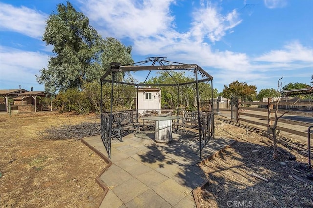 view of patio / terrace featuring a gazebo and a storage unit