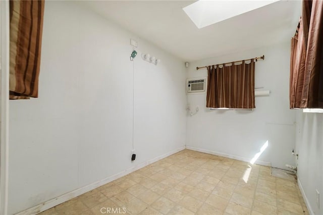 unfurnished room featuring a wall mounted AC and a skylight