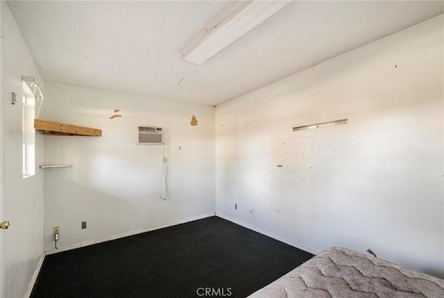 carpeted empty room featuring an AC wall unit