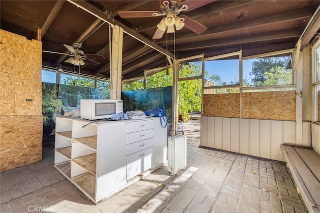 unfurnished sunroom featuring ceiling fan and lofted ceiling