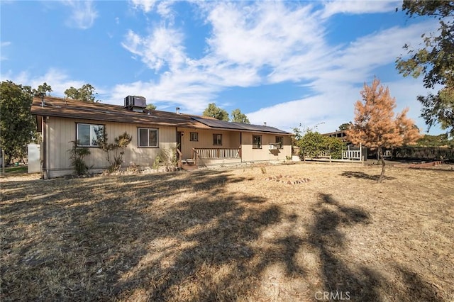 rear view of house featuring solar panels and central air condition unit