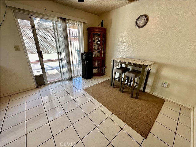 tiled dining space featuring a textured ceiling