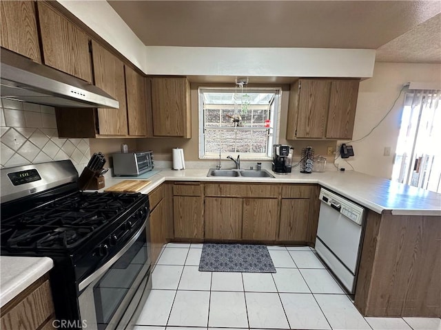 kitchen with kitchen peninsula, gas stove, white dishwasher, extractor fan, and sink