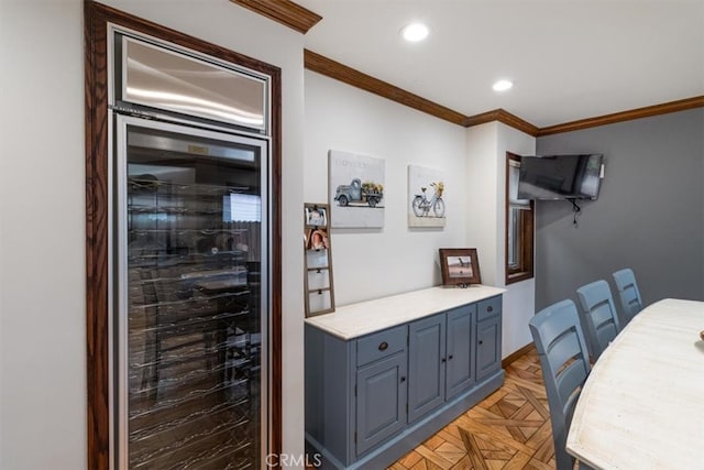 interior space with crown molding, light parquet flooring, and beverage cooler