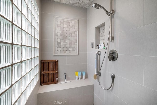 bathroom featuring tile walls and a shower