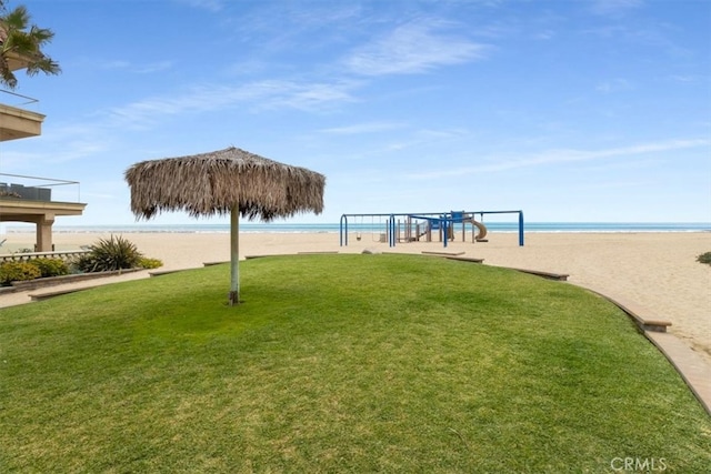 surrounding community with a view of the beach, a yard, and a water view