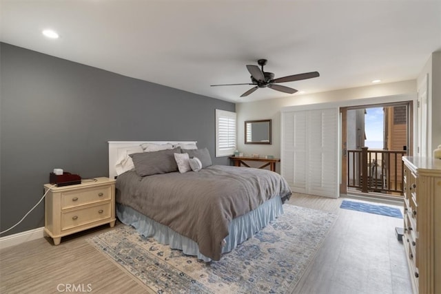 bedroom with multiple windows, light hardwood / wood-style floors, and ceiling fan