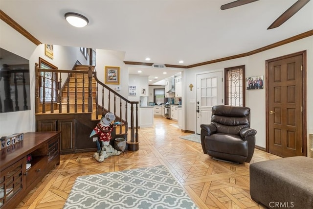 foyer featuring crown molding, light parquet flooring, and ceiling fan