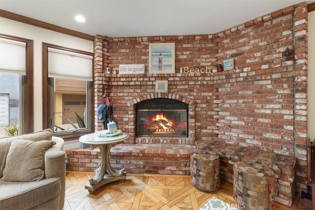 living room featuring light parquet floors, brick wall, ornamental molding, and a brick fireplace