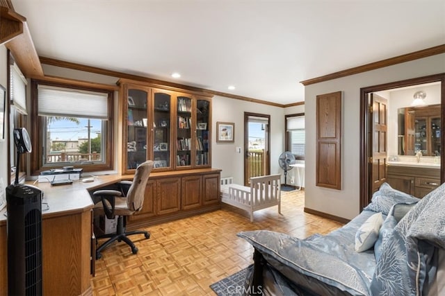 home office with built in desk, crown molding, and light parquet flooring