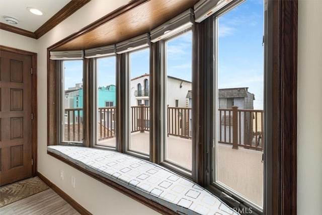 doorway to outside with crown molding, a water view, and plenty of natural light