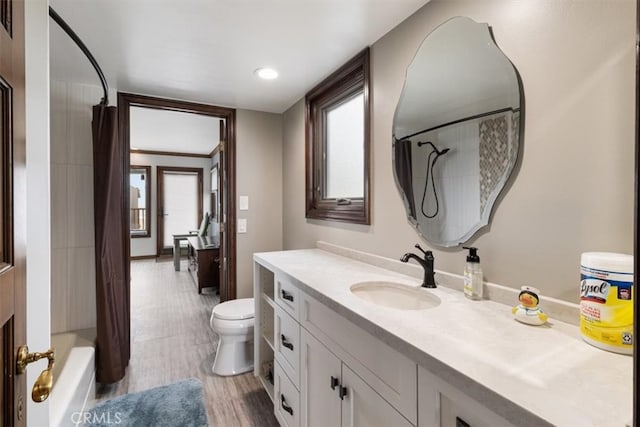 full bathroom featuring vanity, toilet, hardwood / wood-style flooring, and shower / tub combo