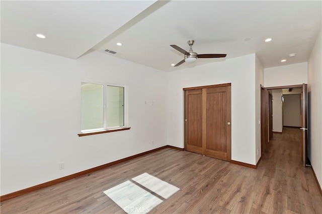 unfurnished bedroom with wood-type flooring, a closet, and ceiling fan