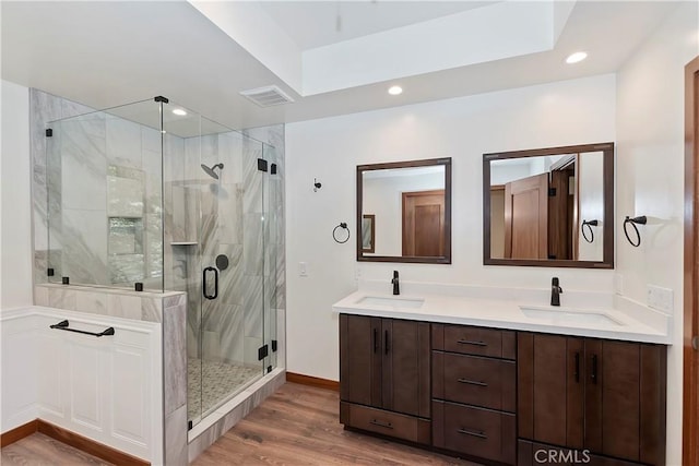 bathroom featuring wood-type flooring, vanity, and an enclosed shower