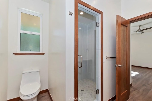 bathroom featuring hardwood / wood-style flooring, ceiling fan, toilet, and walk in shower