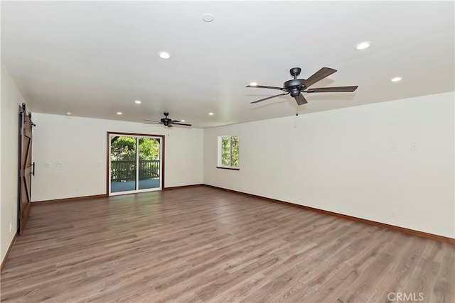 spare room featuring a barn door and light hardwood / wood-style flooring