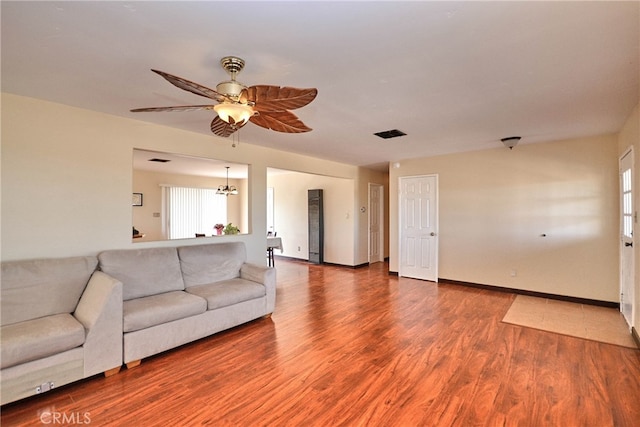 living room featuring hardwood / wood-style floors and ceiling fan with notable chandelier