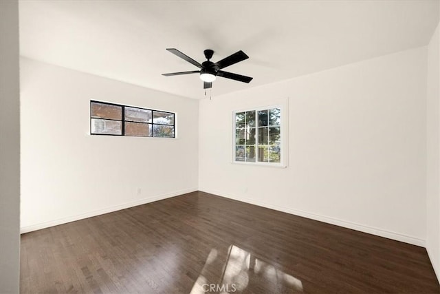 spare room with dark wood-type flooring and ceiling fan