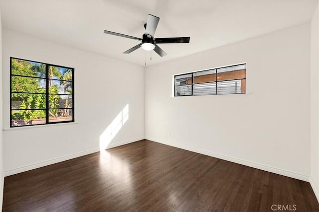 empty room with dark wood-type flooring and ceiling fan