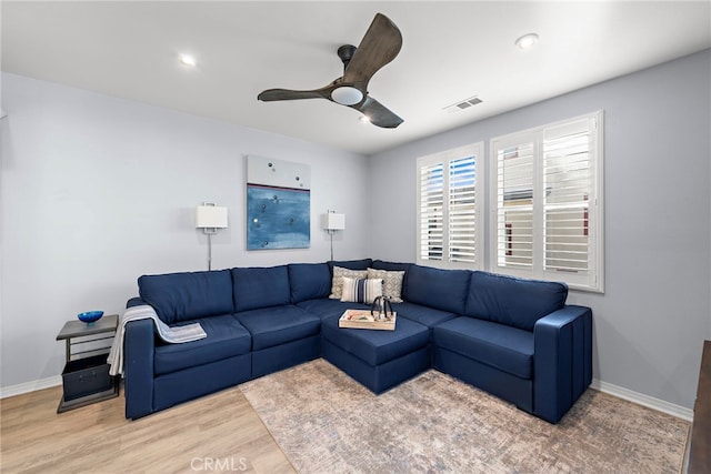 living room featuring wood-type flooring and ceiling fan