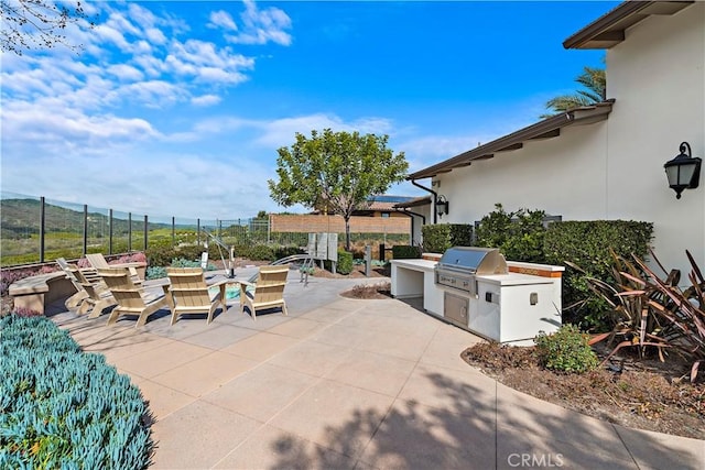 view of patio / terrace featuring an outdoor kitchen and a grill