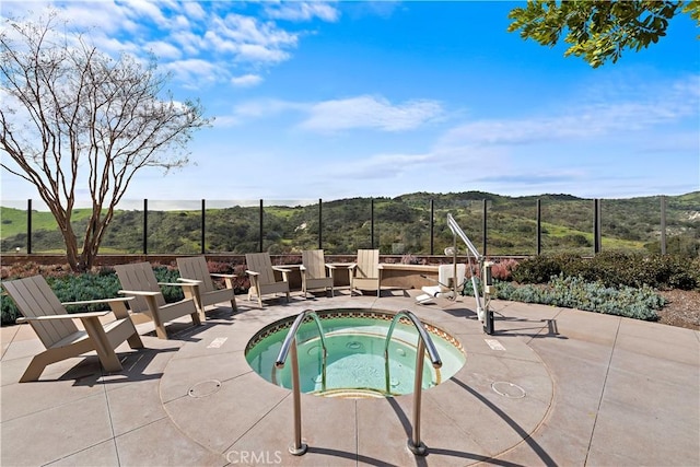 view of pool featuring an in ground hot tub, a mountain view, and a patio