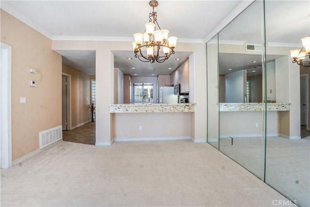 kitchen featuring ornamental molding, light colored carpet, pendant lighting, white refrigerator, and a notable chandelier