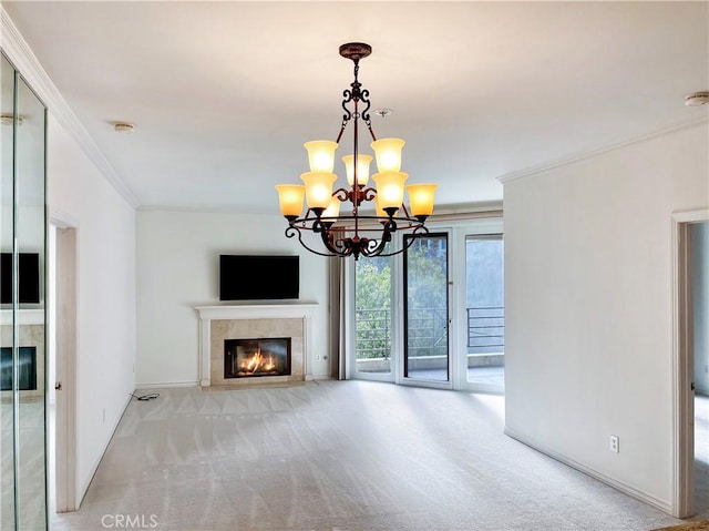 unfurnished living room featuring a tiled fireplace, crown molding, light colored carpet, and a chandelier