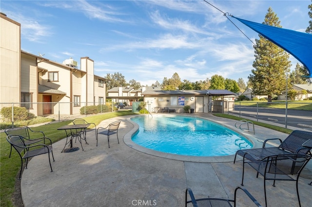 view of swimming pool featuring a patio area, pool water feature, and a lawn