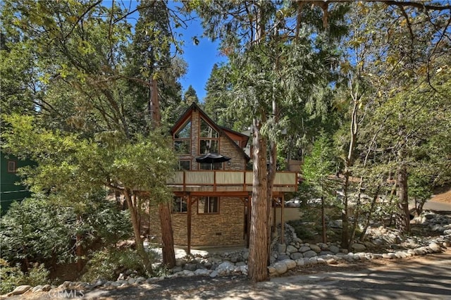 view of home's exterior with a wooden deck and a patio