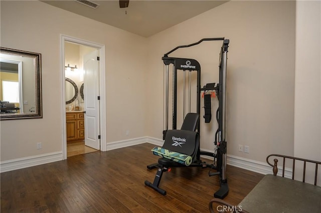 workout room featuring ceiling fan and dark hardwood / wood-style floors