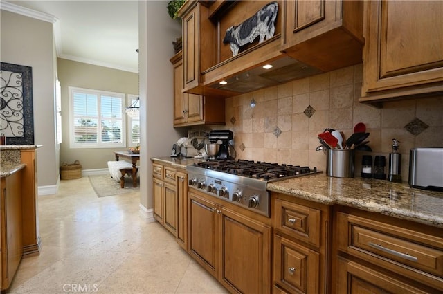 kitchen with decorative backsplash, light stone countertops, ornamental molding, and stainless steel gas cooktop