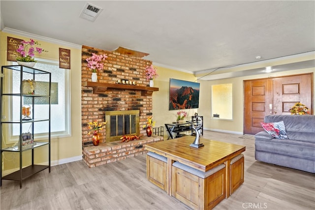 living room with ornamental molding, light hardwood / wood-style flooring, and a brick fireplace