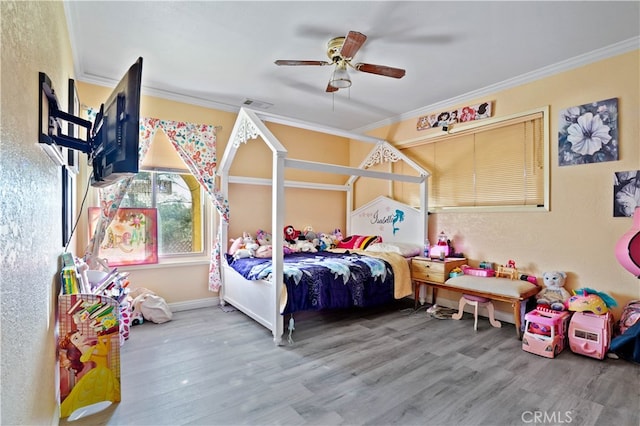 bedroom featuring ceiling fan, crown molding, and wood-type flooring