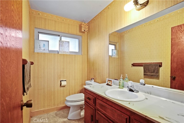 bathroom with toilet, vanity, and tile patterned flooring