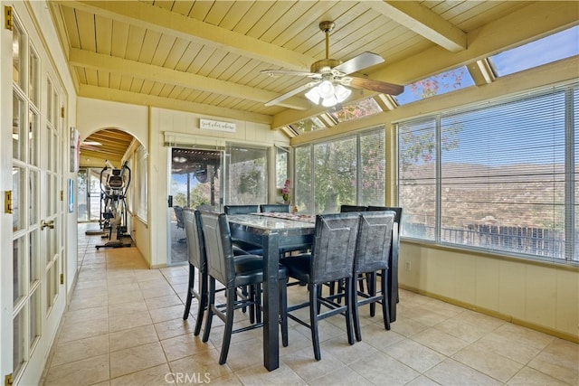 sunroom with ceiling fan, beamed ceiling, wooden ceiling, and a wealth of natural light