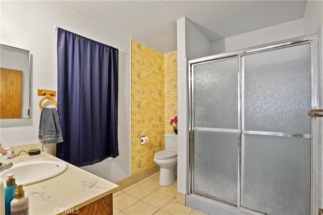 bathroom with vanity, toilet, a shower with shower door, and tile patterned flooring