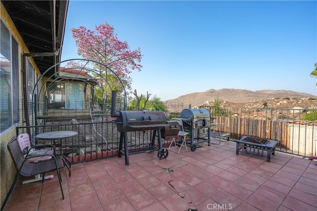 view of patio with an outdoor fire pit and a mountain view