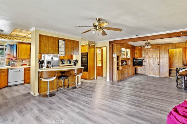 kitchen with a breakfast bar area, dishwasher, stainless steel fridge with ice dispenser, and light hardwood / wood-style floors