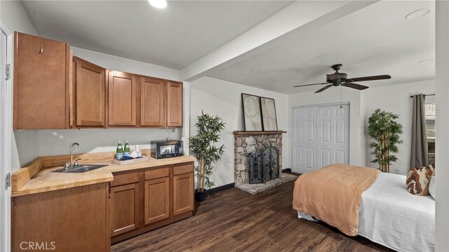 15757 Creswick Dr, La Mirada, CA 90638 - bedroom featuring a sink, dark wood finished floors, a fireplace, a closet, and baseboards
