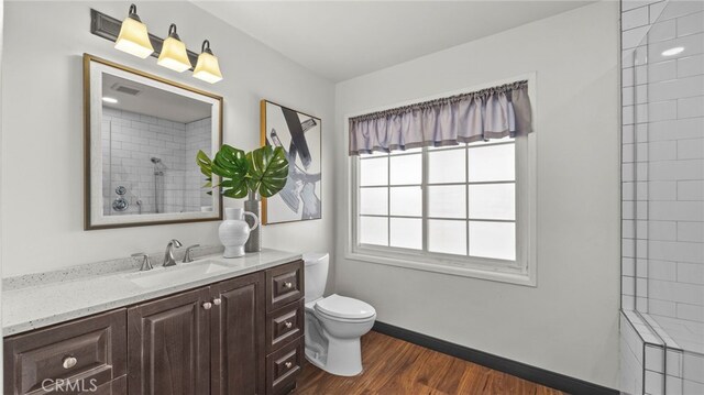15757 Creswick Dr, La Mirada, CA 90638 - bathroom with vanity, toilet, wood finished floors, tiled shower, and baseboards