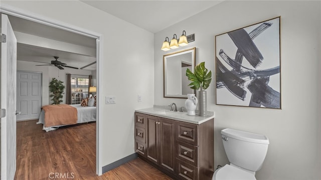 bathroom featuring ceiling fan, vanity, wood-type flooring, and toilet