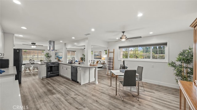 kitchen featuring white cabinets, kitchen peninsula, black appliances, and a wealth of natural light