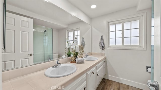 bathroom featuring wood-type flooring, vanity, toilet, and an enclosed shower