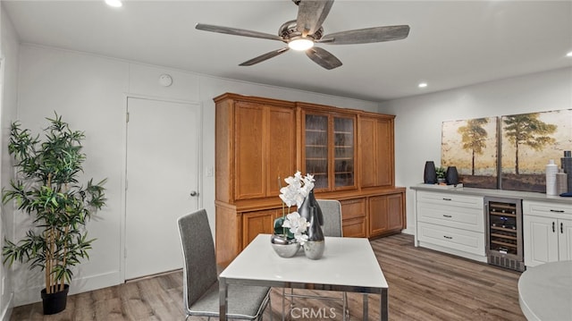 office space with ceiling fan, light hardwood / wood-style floors, and beverage cooler