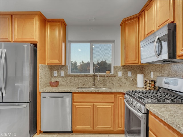 kitchen featuring light tile patterned flooring, appliances with stainless steel finishes, sink, and decorative backsplash