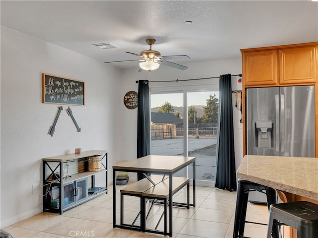 dining area featuring a textured ceiling, light tile patterned flooring, and ceiling fan